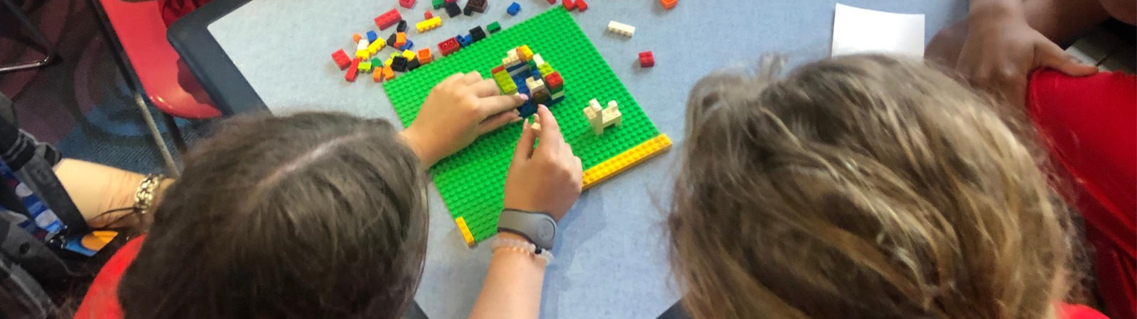 Students working together on a lego project sitting around a table